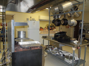 Stoves, prep area, serving area, fridge, with sings to the right and left of this photo.